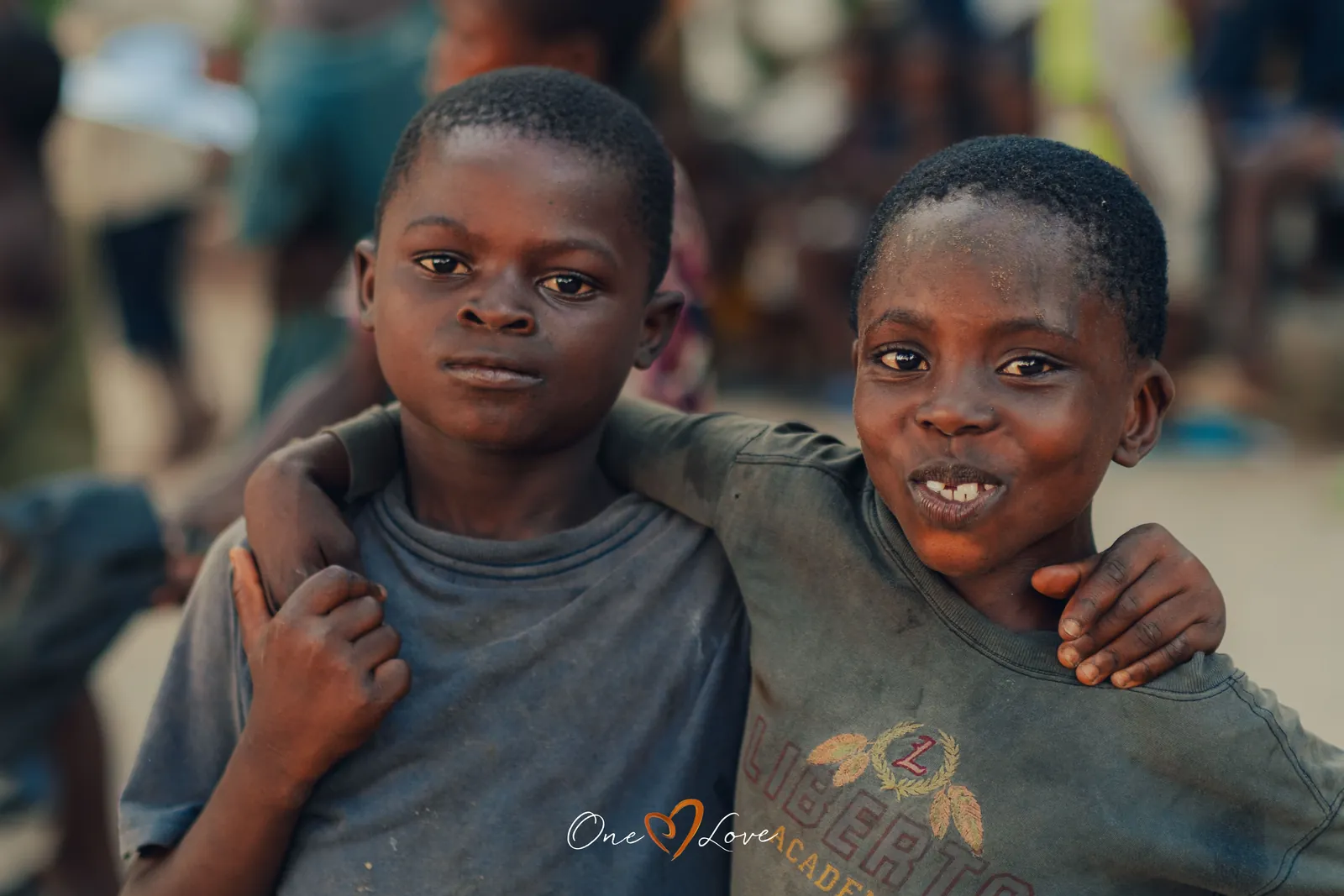 Two boys from the day centre, arm in arm, smiling.