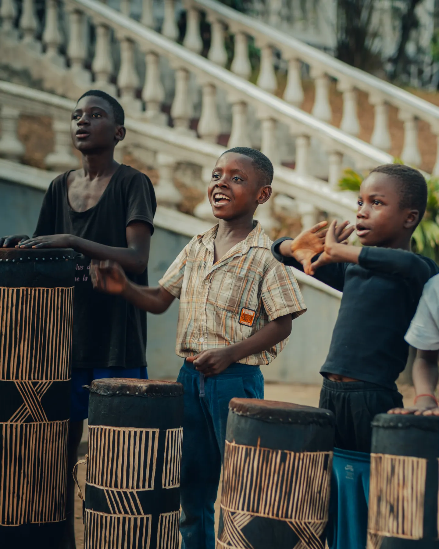 Children standing behind tam-tam drums during the music workshop.