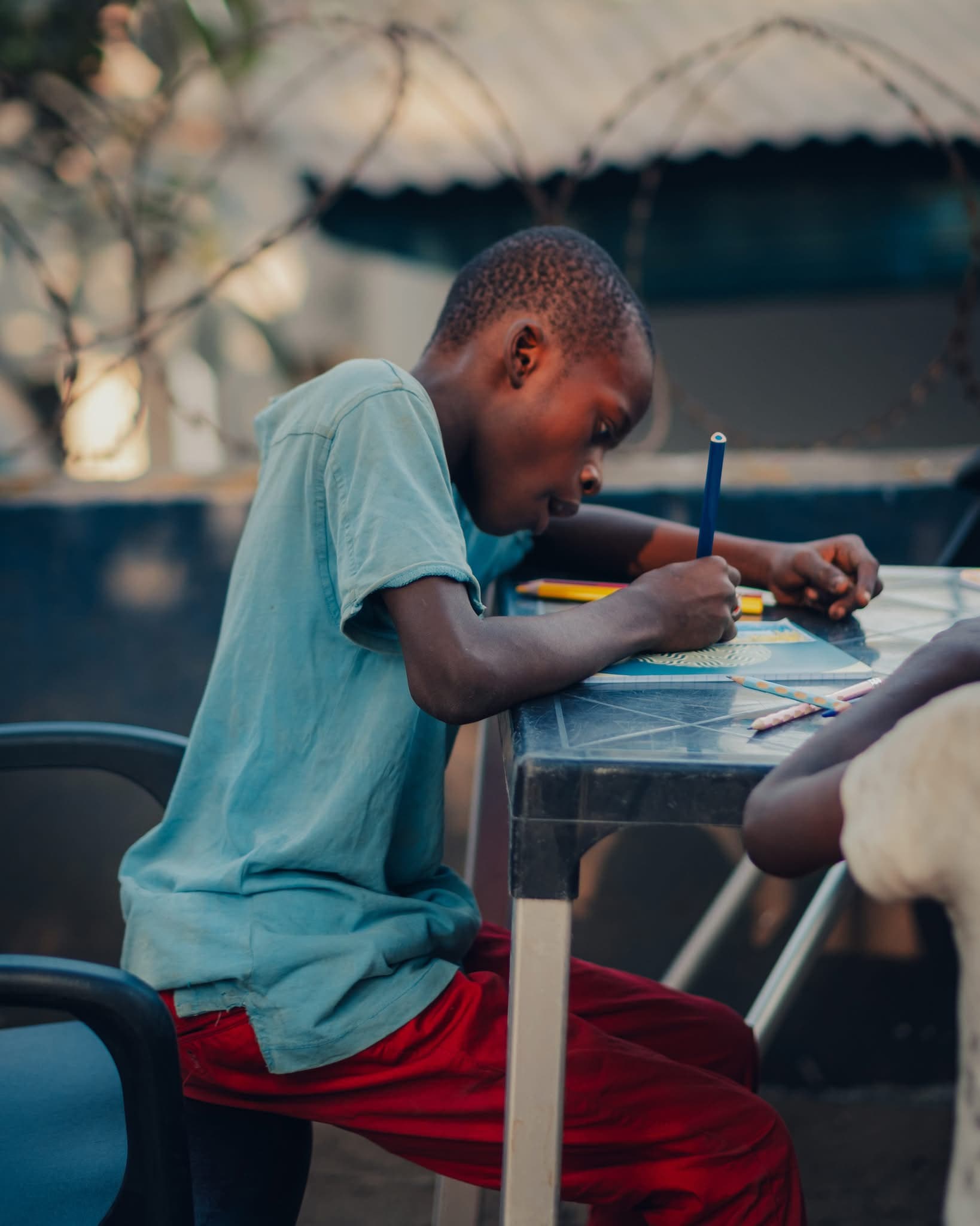 Un garçon écrit, concentré.